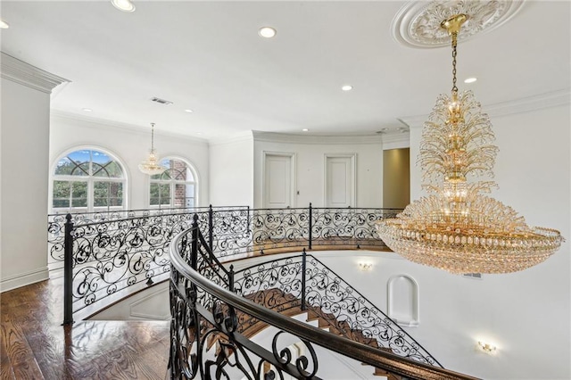 hall with an inviting chandelier, ornamental molding, and dark hardwood / wood-style floors