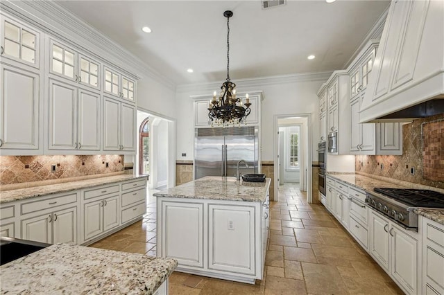 kitchen featuring a center island with sink, white cabinets, hanging light fixtures, and appliances with stainless steel finishes