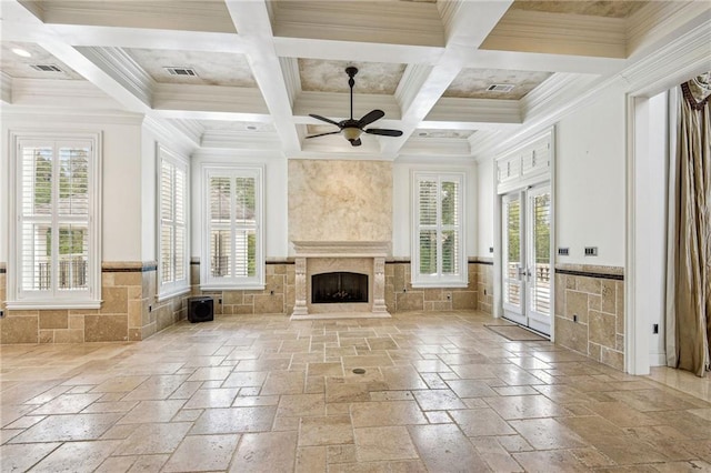 unfurnished sunroom with coffered ceiling, french doors, a high end fireplace, ceiling fan, and beamed ceiling