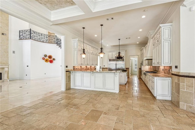 kitchen with premium range hood, decorative light fixtures, tasteful backsplash, white cabinets, and a fireplace