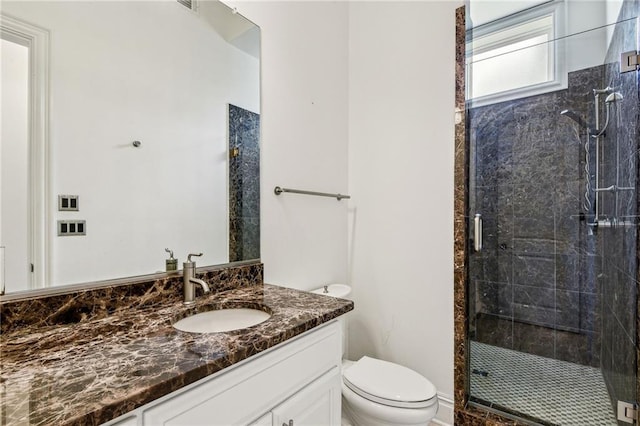 bathroom with toilet, a shower with shower door, and vanity