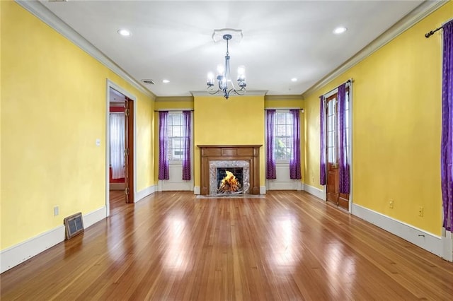 unfurnished living room featuring a premium fireplace, crown molding, and a healthy amount of sunlight