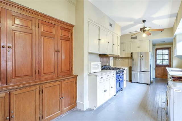 kitchen with ceiling fan, light hardwood / wood-style floors, backsplash, and appliances with stainless steel finishes