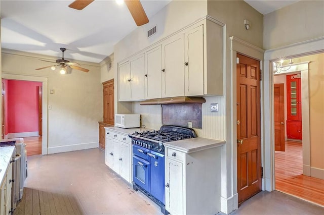 kitchen featuring decorative backsplash, stove, white cabinetry, and double oven range