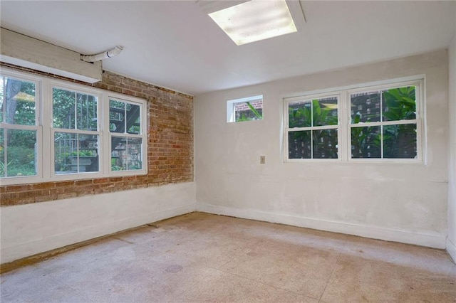 spare room featuring brick wall