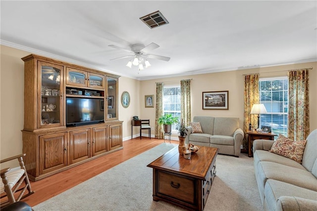 living room with ceiling fan, light hardwood / wood-style floors, plenty of natural light, and ornamental molding