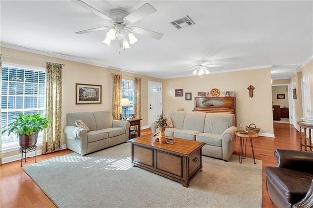 living room with light hardwood / wood-style floors, ceiling fan, and ornamental molding