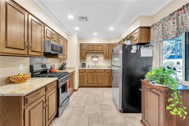 kitchen featuring light tile patterned flooring, stainless steel appliances, crown molding, and sink