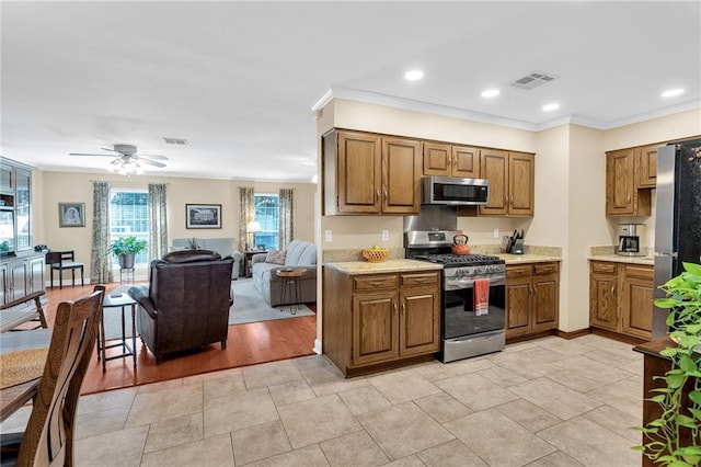 kitchen featuring ceiling fan, crown molding, and appliances with stainless steel finishes