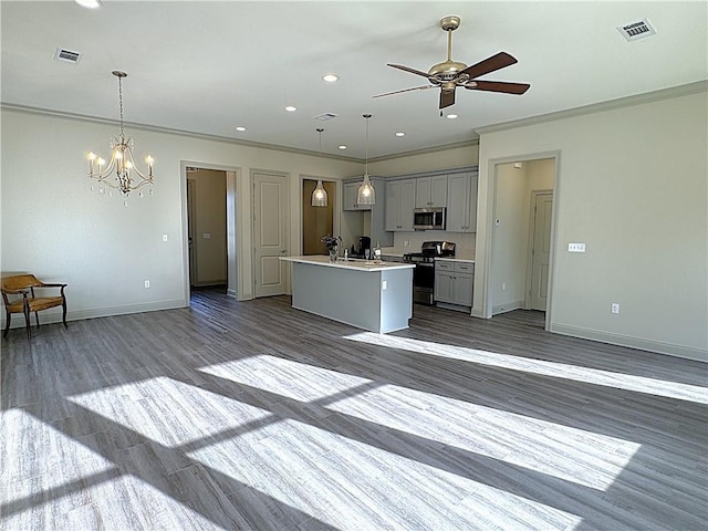 kitchen featuring pendant lighting, gray cabinets, a center island with sink, and stainless steel appliances