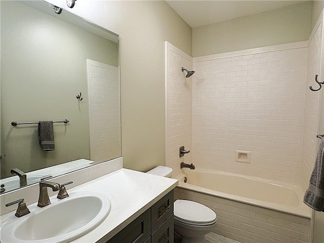 full bathroom featuring vanity, tiled shower / bath, and toilet