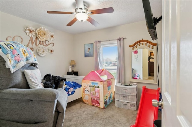 carpeted bedroom featuring ceiling fan and a textured ceiling