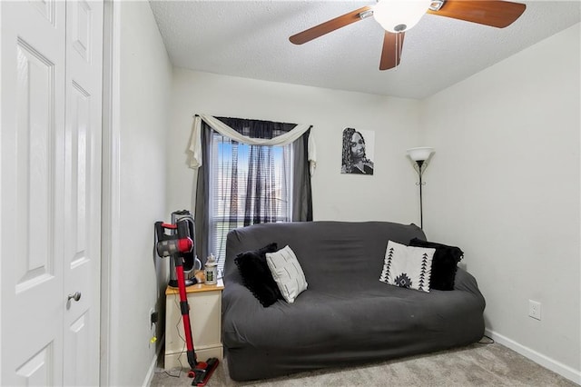 interior space featuring ceiling fan, light colored carpet, and a textured ceiling