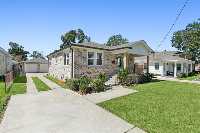 view of front of home featuring an outbuilding, a garage, covered porch, and a front yard