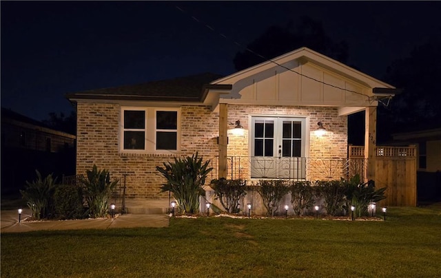 view of front facade featuring a lawn and french doors