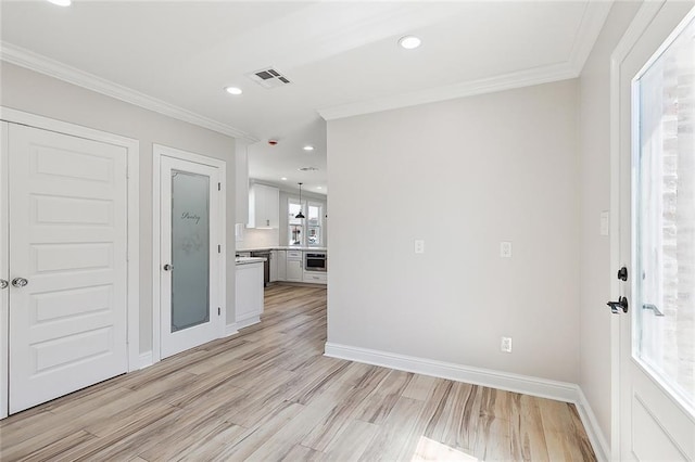 unfurnished room featuring crown molding and light hardwood / wood-style flooring