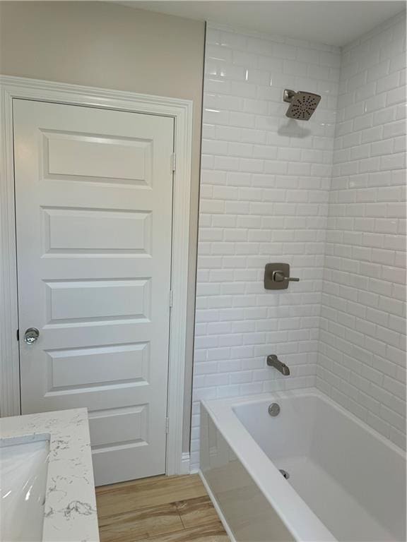 bathroom with vanity, hardwood / wood-style floors, and tiled shower / bath