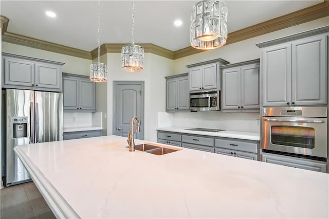 kitchen with stainless steel appliances, hanging light fixtures, gray cabinetry, and sink