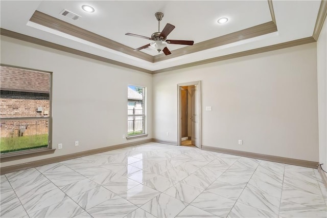 unfurnished room featuring a raised ceiling, crown molding, and ceiling fan