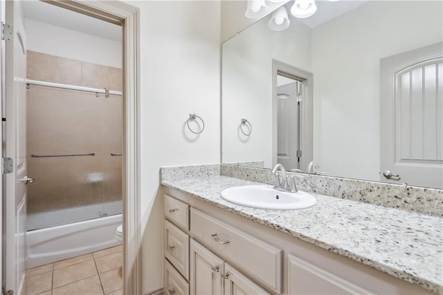 full bathroom featuring tile patterned flooring, vanity, combined bath / shower with glass door, and toilet