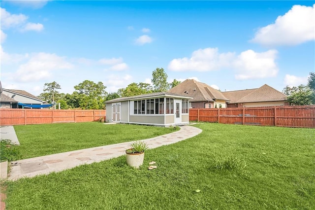 back of house featuring a sunroom and a yard