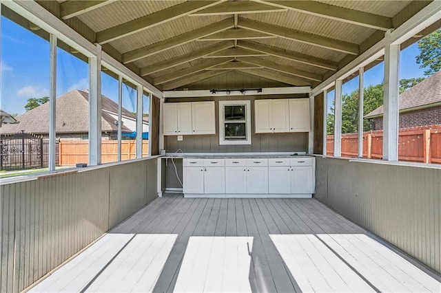 exterior space featuring vaulted ceiling with beams