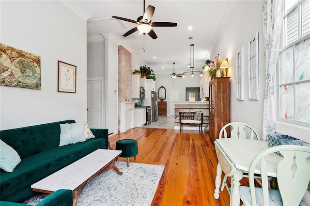 living room with ceiling fan, ornamental molding, and light hardwood / wood-style floors