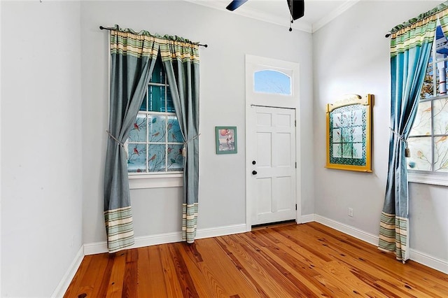 entryway featuring hardwood / wood-style flooring, ornamental molding, and ceiling fan