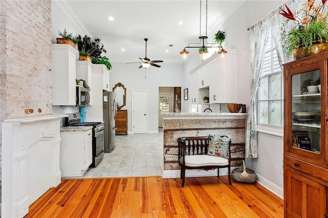 kitchen with crown molding, ceiling fan, stainless steel appliances, light hardwood / wood-style floors, and white cabinets