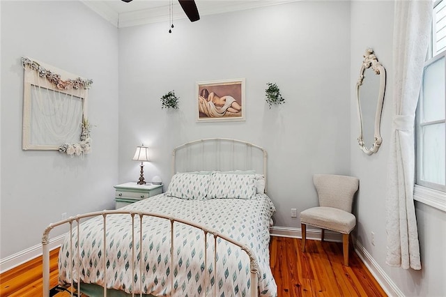 bedroom featuring ceiling fan, ornamental molding, hardwood / wood-style floors, and multiple windows