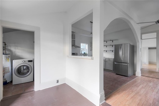 laundry room featuring ceiling fan, sink, dark wood-type flooring, water heater, and washer / clothes dryer