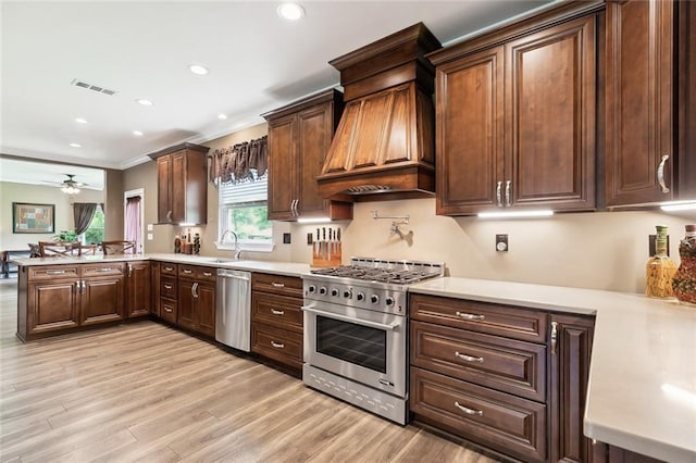 kitchen featuring ceiling fan, sink, kitchen peninsula, appliances with stainless steel finishes, and custom exhaust hood