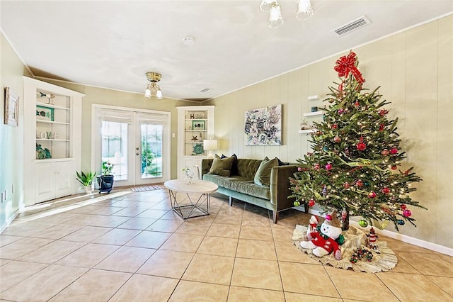 tiled living room featuring built in shelves and french doors