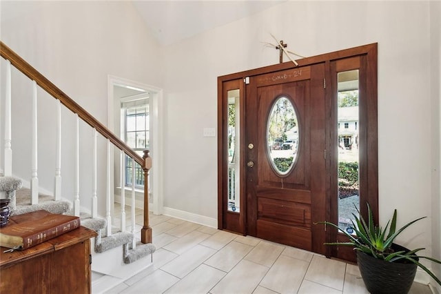 foyer featuring high vaulted ceiling, a healthy amount of sunlight, and light tile patterned floors