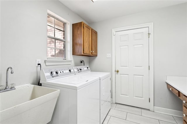 laundry area with washer and dryer, sink, light tile patterned flooring, and cabinets