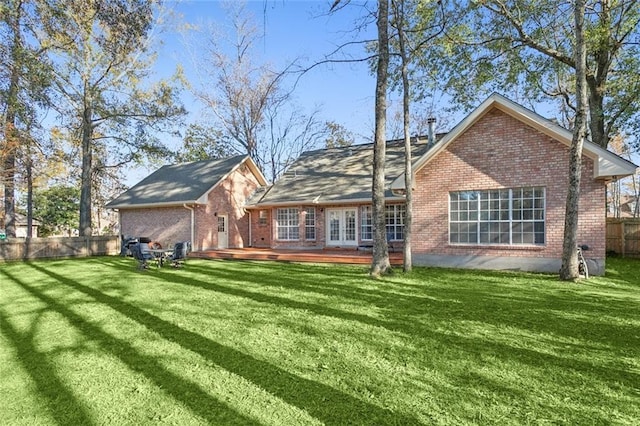 rear view of property with a yard and a deck