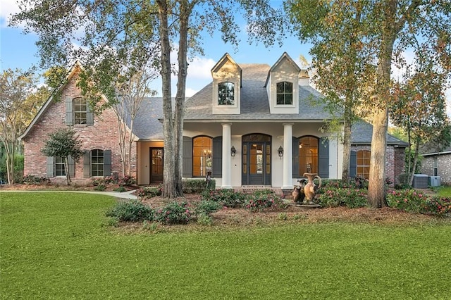 view of front of house featuring a porch, a front lawn, and cooling unit