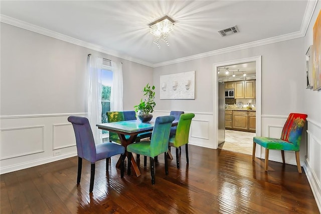 dining area featuring a chandelier, dark hardwood / wood-style flooring, and crown molding