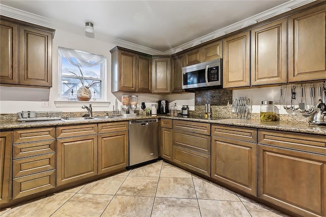 kitchen featuring appliances with stainless steel finishes, crown molding, sink, stone countertops, and light tile patterned flooring