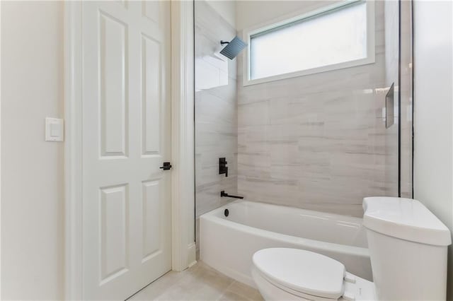 bathroom featuring tiled shower / bath, tile patterned floors, and toilet