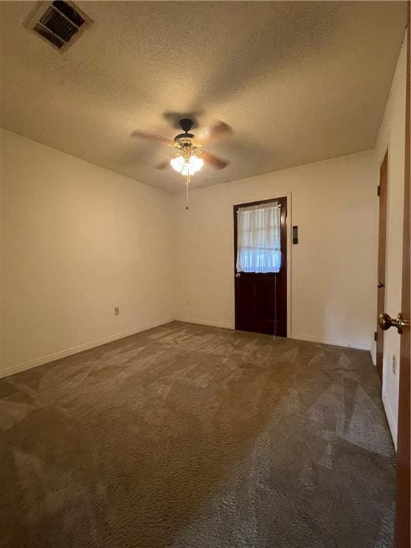 spare room with ceiling fan, a textured ceiling, and dark colored carpet