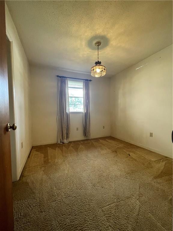 carpeted empty room featuring a textured ceiling