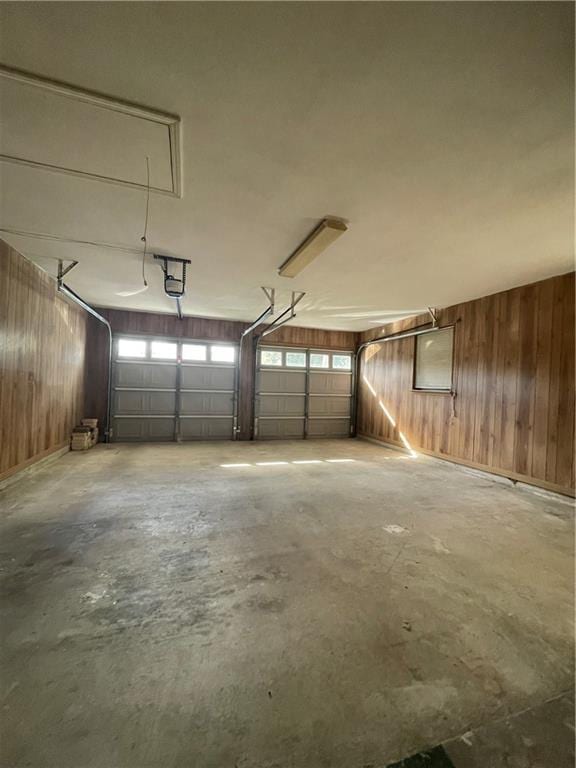 garage featuring wood walls and a garage door opener