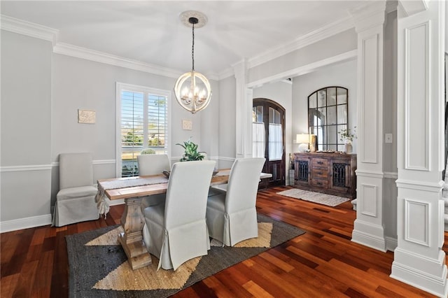 dining area featuring dark hardwood / wood-style floors, ornate columns, crown molding, and a chandelier