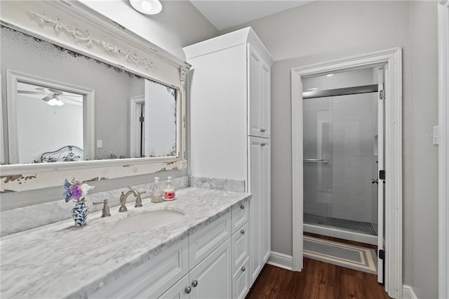 bathroom with ceiling fan, vanity, an enclosed shower, and hardwood / wood-style flooring