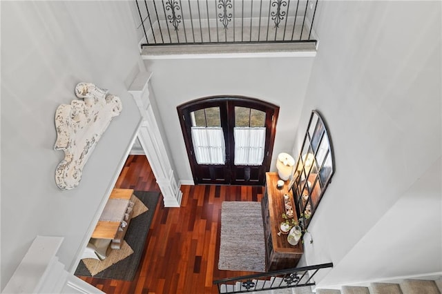 foyer featuring dark hardwood / wood-style flooring, french doors, and a towering ceiling