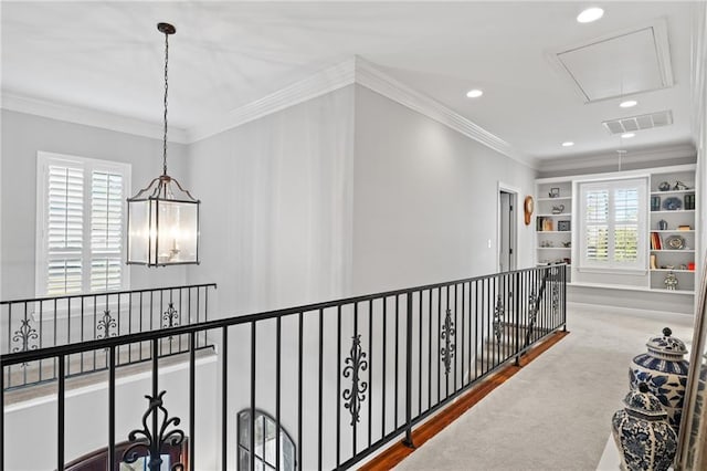 corridor with carpet flooring, built in features, and crown molding