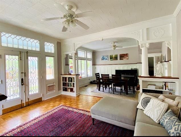 sunroom with ceiling fan and decorative columns