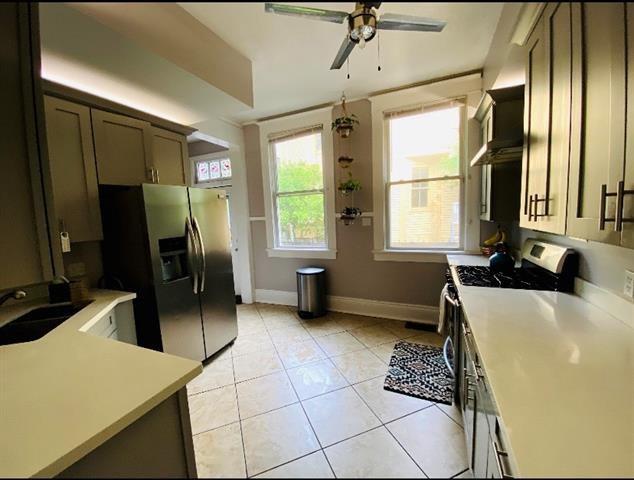 kitchen with ceiling fan, sink, light tile patterned floors, and stainless steel appliances