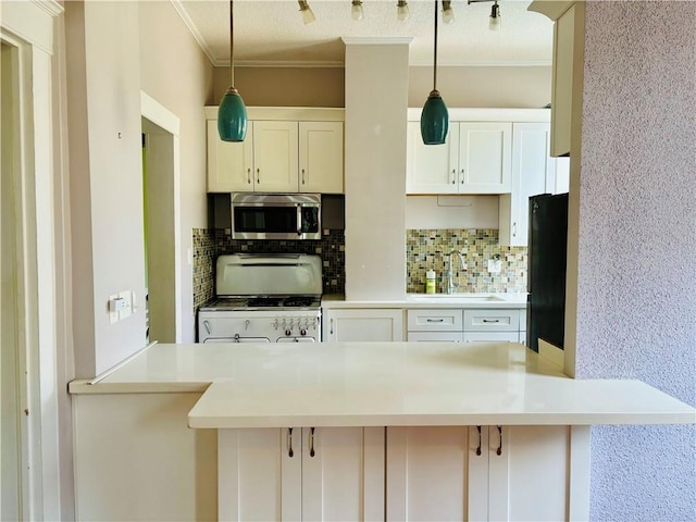 kitchen featuring backsplash, ornamental molding, white range, decorative light fixtures, and white cabinets